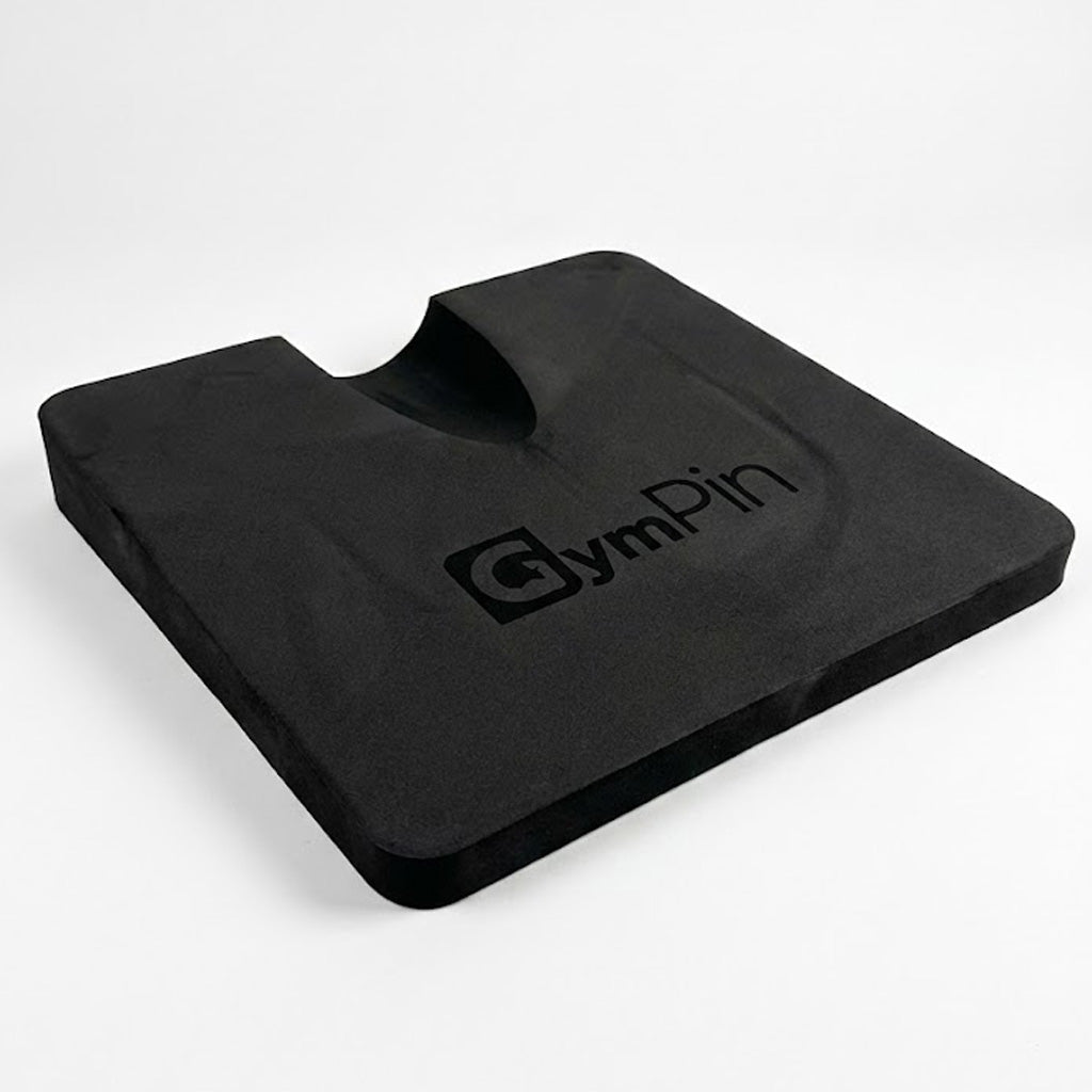 GymPin hamstring pad featuring a contoured cut-out and dense black foam design, used to increase range of motion and provide support during hamstring curl and glute training.